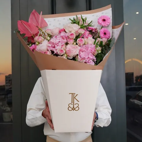 Close-up of Flamingo Radiance bouquet featuring pink roses, gerbera daisies and eucalyptus accents